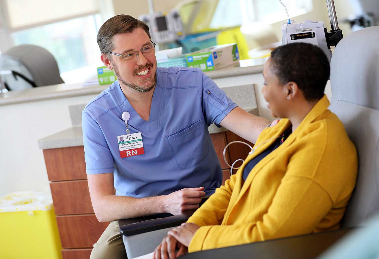 medical-services-cancer-center-signature-card A registered nurse smiling with a patient.